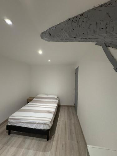 a bedroom with a bed in a white room at Appartement rénové en centre-ville avec terrasse in Millau