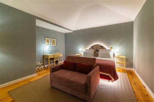 a bedroom with a bed and a chair in a room at Pestana Quinta Perestrello in Funchal