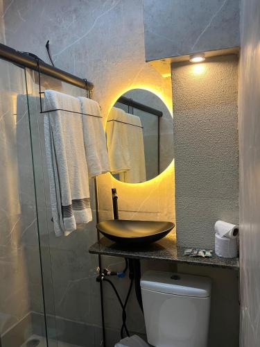 a bathroom with a sink and a mirror and a toilet at flat Luiz Carlos Mouzinho in Teresina