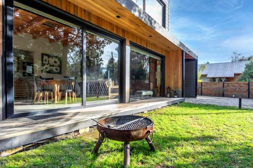 una casa con una parrilla en el patio en BOG Cherry House, en Villa La Angostura