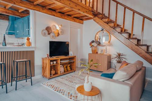 a living room with a couch and a television at Yellow House - Casa 1 in Angra do Heroísmo