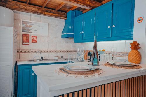 eine Küche mit blauen Schränken und einer weißen Arbeitsplatte in der Unterkunft Yellow House - Casa 1 in Angra do Heroísmo