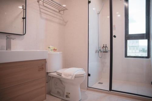 a bathroom with a shower and a toilet and a sink at Nam San Private Villa in Zhuangwei