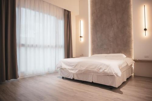 a bedroom with a white bed and a large window at Nam San Private Villa in Zhuangwei