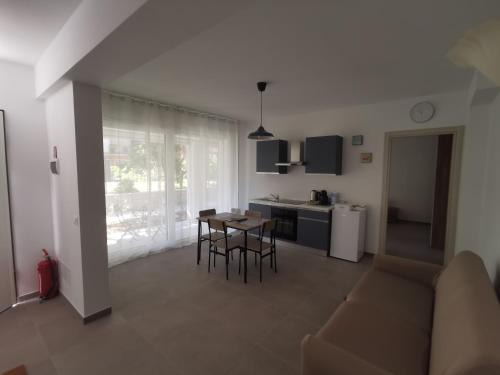 a living room with a couch and a table and a kitchen at La Bianca Dimora in Sulmona