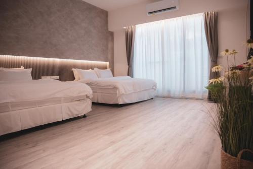 a hotel room with two beds and a window at Nam San Private Villa in Zhuangwei