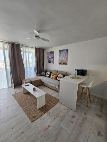 ein Wohnzimmer mit Sofa und Tisch in der Unterkunft Dinas KOKA Resort in Playa del Ingles
