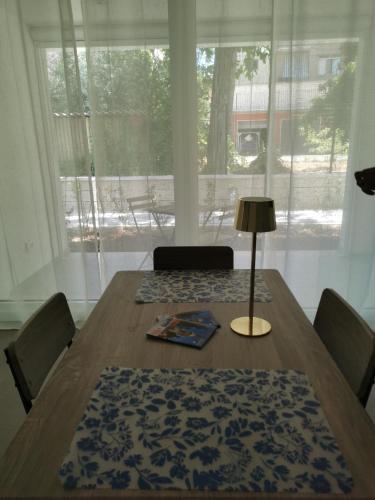 a dining room table with a lamp and a window at La Bianca Dimora in Sulmona