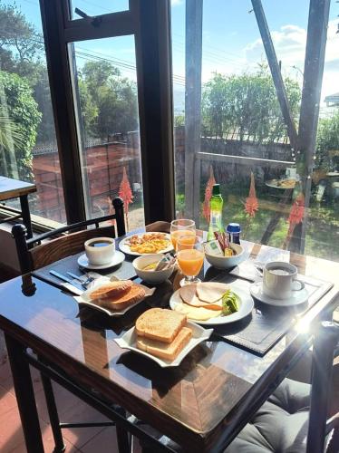a table with breakfast food on it with a window at Yemanya Hostal in Concón