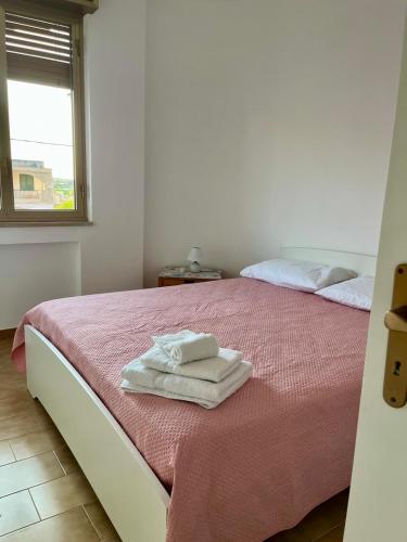 a bedroom with two beds with towels on the bed at La terrazza sul mare, 44 in Marzamemi