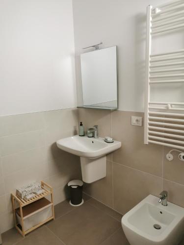 a bathroom with a sink and a mirror and a toilet at La Bianca Dimora in Sulmona