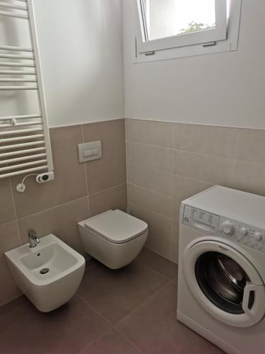 a bathroom with a toilet sink and a washing machine at La Bianca Dimora in Sulmona