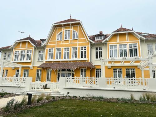 a large yellow and white building with a yard at Maison St Georges d'Oléron-Fort Boyard accès Océan 2-6 personnes in La Celle-sous-Gouzon