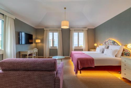 a bedroom with a large bed and a couch at Pestana Quinta Perestrello in Funchal