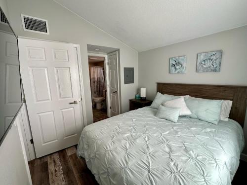 1 dormitorio con cama blanca y puerta blanca en Cottage 23, The Lighthouse - Dora Canal Court - a downtown, waterfront community, en Tavares