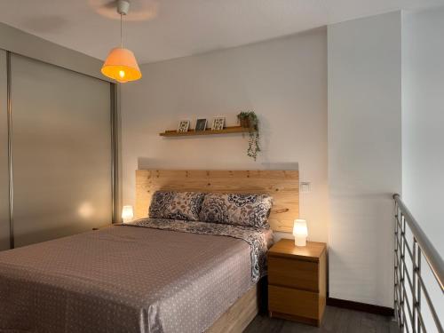 a bedroom with a bed and a wooden headboard at Lujoso Loft La Moraleja in Madrid