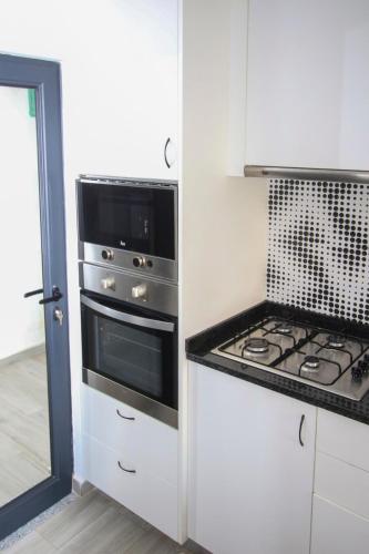 a kitchen with a stove and a stove top oven at Cozy 2 BDR Apartment Near Murdeira Beach LCGR in Palha Verde