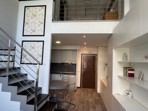 a room with a staircase and a kitchen with a table at Lujoso Loft La Moraleja in Madrid