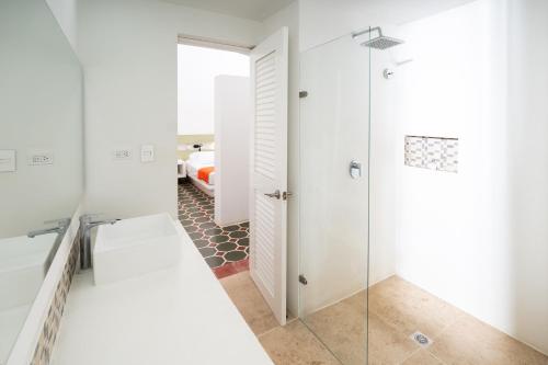 a bathroom with a shower and a glass door at Hotel Las Palmeras in Villeta