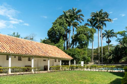 a building with palm trees in the background at Hotel Las Palmeras in Villeta