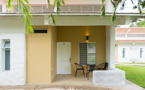 a patio with chairs and a table in front of a house at Hotel Las Palmeras in Villeta