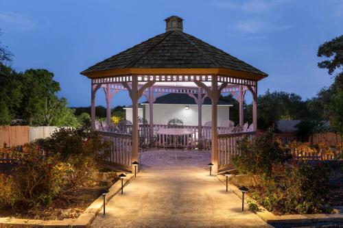 a wooden gazebo with a table in it at Days Inn by Wyndham Suites Fredericksburg in Fredericksburg