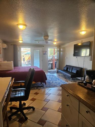 a bedroom with a bed and a couch and a table at Camaray Motel in Oroville