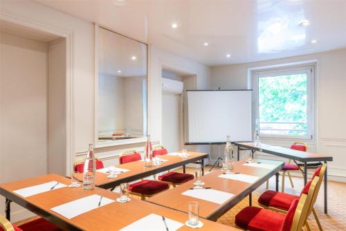 a classroom with tables and chairs and a whiteboard at Best Western Ronceray Opéra in Paris