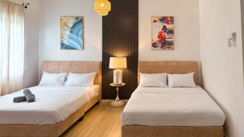 a bedroom with two beds and a lamp at Comfy Terrace House Homestay near Zoo with Netflix in Taiping