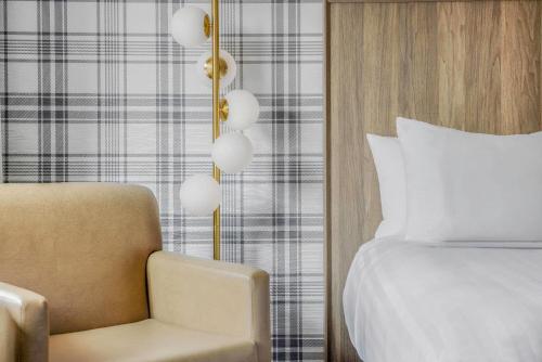 a bedroom with a bed and a chair at Travelodge by Wyndham Niagara Falls At the Falls in Niagara Falls