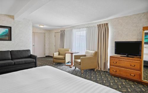 a hotel room with a bed and a flat screen tv at Travelodge by Wyndham Niagara Falls At the Falls in Niagara Falls
