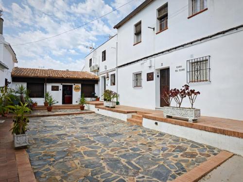 a courtyard of a white building with a stone floor at Casa rural El Nido in Constantina