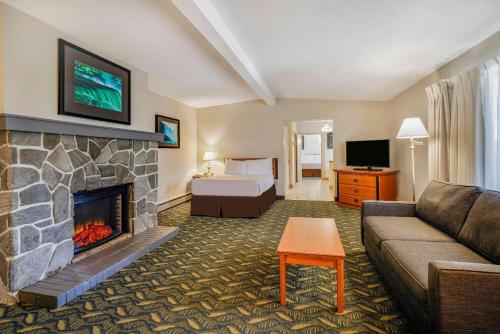 a living room with a couch and a fireplace at Travelodge by Wyndham Niagara Falls At the Falls in Niagara Falls