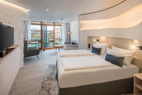 a hotel room with two beds and a flat screen tv at Best Western Plus Kurhotel an der Obermaintherme in Bad Staffelstein