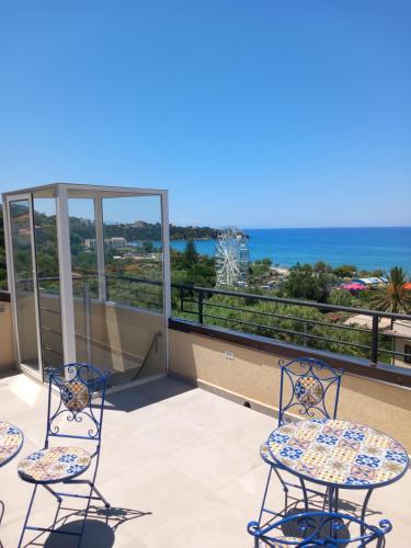 a balcony with chairs and a view of the ocean at Holidays Cefalù Rooms in Cefalù