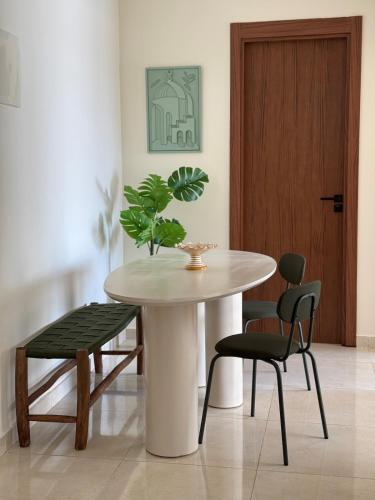 a table and chairs with a plant on top of it at Appartement moderne avec piscine, 2 chambres in Bouznika