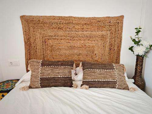 a bed with a large headboard and two pillows at Casa rural El Nido in Constantina