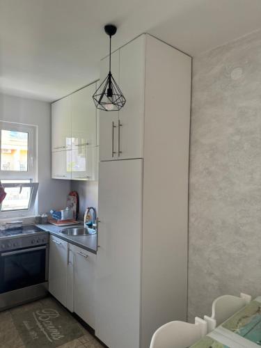 a kitchen with a white refrigerator and a sink at Apartment Klikovac in Kravlja