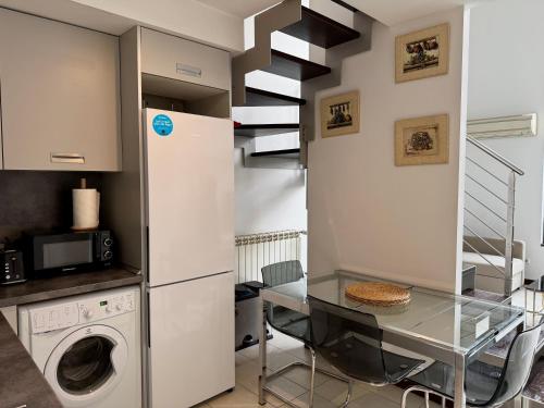 a kitchen with a washing machine and a glass table at Lujoso Loft La Moraleja in Madrid