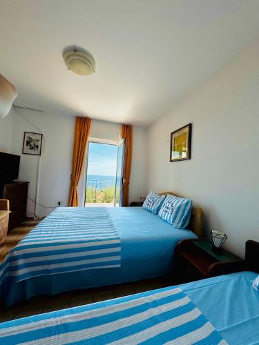 a bedroom with a blue bed and a window at Turkuaz Boutique Hotel in Sveti Stefan