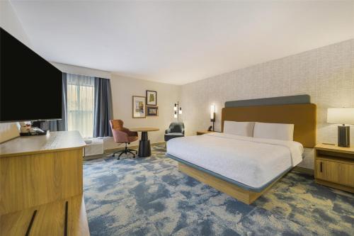 a hotel room with a bed and a flat screen tv at Hampton Inn Huntsville-Arsenal/South Parkway in Huntsville