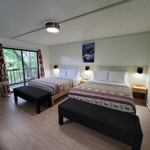 a bedroom with two beds and a window at Ski Mountain Lodge in Gatlinburg