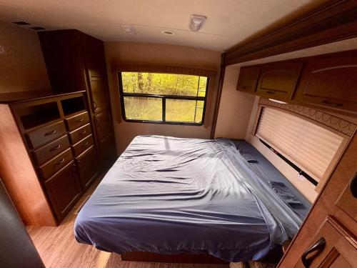 a small bedroom with a bed in an rv at Glacier Park Hideaway in Columbia Falls
