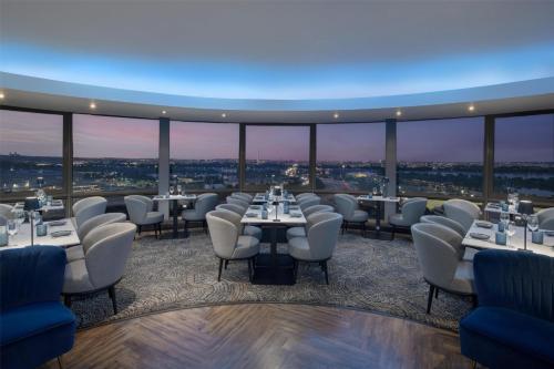 a restaurant with tables and chairs with a view at DoubleTree by Hilton Washington DC – Crystal City in Arlington