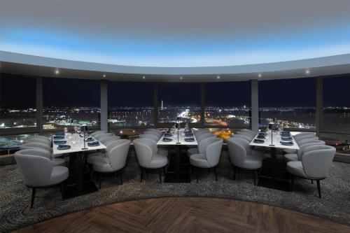 a restaurant with tables and chairs and a view of the city at DoubleTree by Hilton Washington DC – Crystal City in Arlington