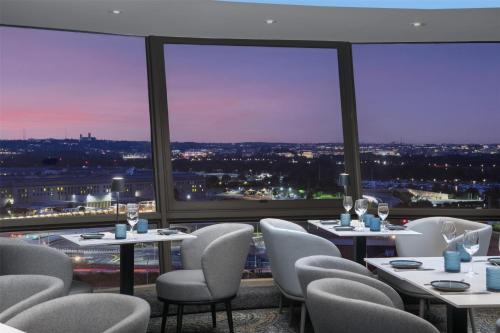 a restaurant with tables and chairs and a view of the city at DoubleTree by Hilton Washington DC – Crystal City in Arlington
