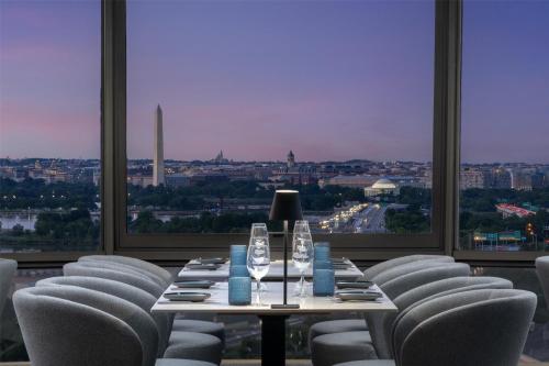 a dining room with a table and chairs with a view at DoubleTree by Hilton Washington DC – Crystal City in Arlington