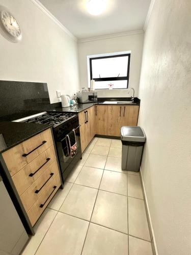 a small kitchen with a stove and a window at Pelican Lodge Guesthouse in Sedgefield