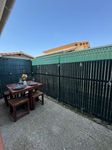 a table and benches in front of a fence at Peaceful oasis Meet & airport in Aussonne
