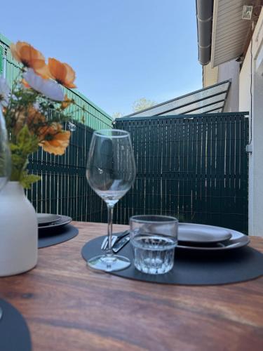 a table with plates and a wine glass on a balcony at Peaceful oasis Meet & airport in Aussonne